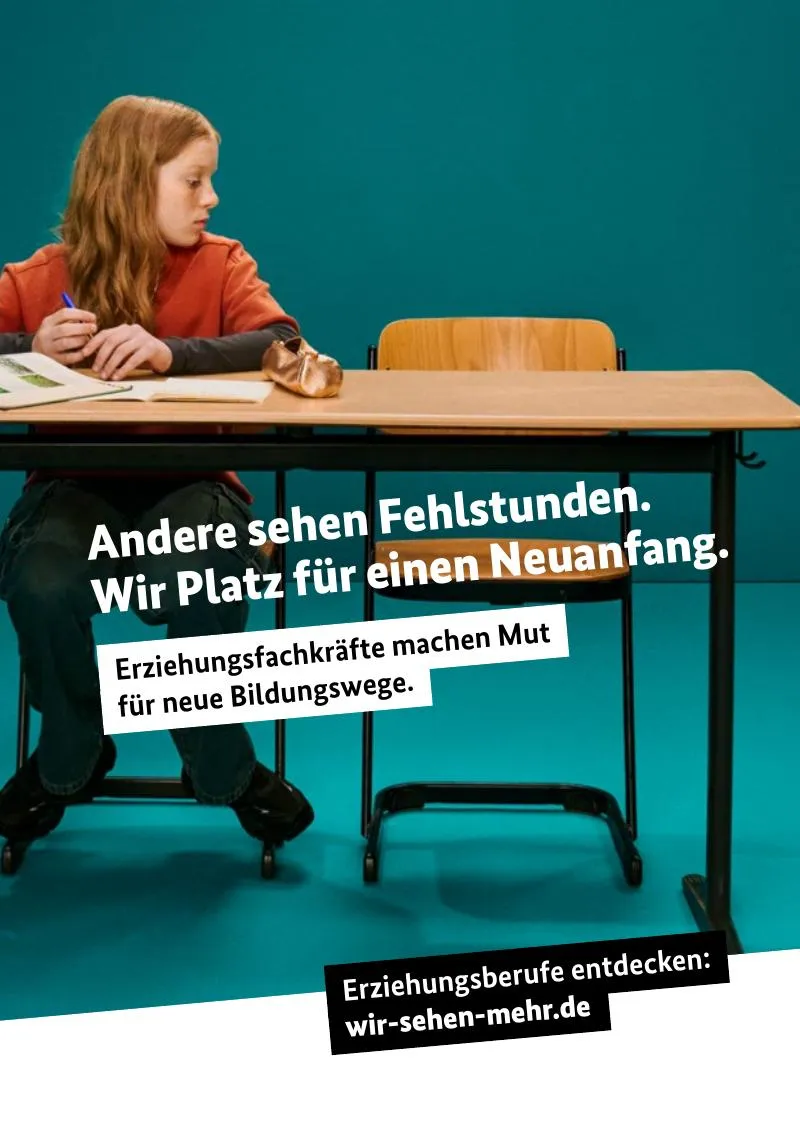 Ein Mädchen sitzt allein an einem Schultisch und schaut zur Seite auf einen leeren Stuhl.